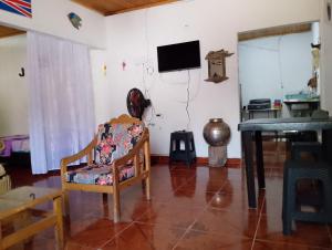 a living room with a chair and a tv on the wall at Casa Sol y Alegría in Honda