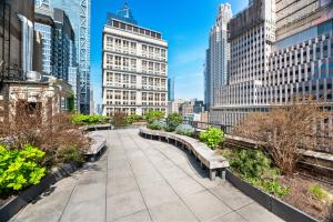a park with benches in a city with tall buildings at 17John Residences in New York