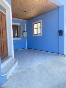 a blue room with a door and a window at Albatros rooms in Vathi