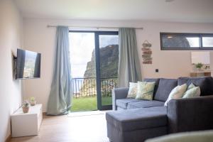 a living room with a couch and a sliding glass door at Cantinho FF in Santana