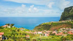 a village on a hill next to the ocean at Cantinho FF in Santana