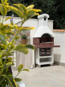 a wood fired pizza oven on a white wall at Marluna in Custonaci