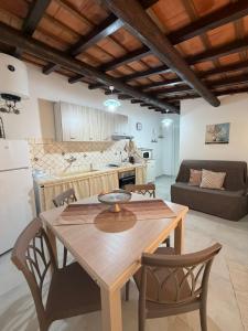 a kitchen and living room with a wooden table and chairs at Marluna in Custonaci