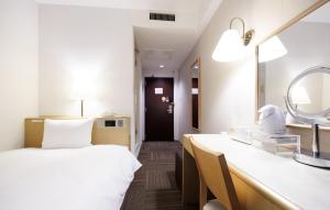 a hotel room with a bed and a mirror at Court Hotel Mito in Mito