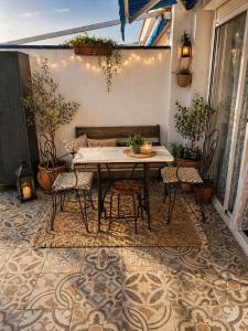 a patio with a table and chairs on a rug at Luxury art Apartamenty in Pineda de Mar