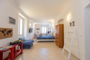 a living room with a bed and a room with a ladder at Ria Apartment in Le Grazie