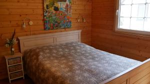 a bedroom with a bed in a wooden room at Ferienhaus Milan mit Ruderboot - 300 m vom Fleesensee in Silz