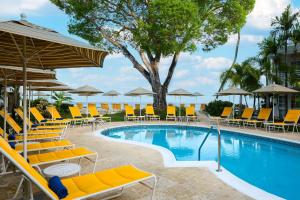 a pool with chairs and umbrellas at a resort at Treasure Beach Art Hotel, An Autograph Collection All-Inclusive Resort in Saint James