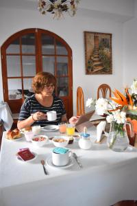 Eine Frau sitzt mit einem Teller Essen an einem Tisch. in der Unterkunft Mi Valle in Cafayate