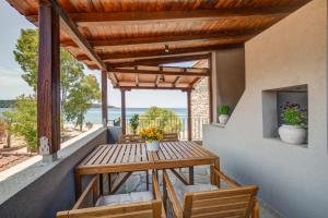 a wooden table and chairs on a balcony with a view of the ocean at EJ Boutique Suites in Milina