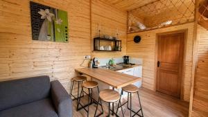 a kitchen with a table and stools in a cabin at Cabane insolite en pleine nature - La cabane de Dim in Grumesnil