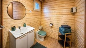 a bathroom with a toilet and a sink and a mirror at Cabane insolite en pleine nature - La cabane de Dim in Grumesnil +10 photos