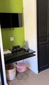 a room with a black counter and a pink stool at La louva in Les Brugassières