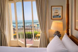 a hotel room with a bed and a large window at The Royal Harbour Hotel in Ramsgate