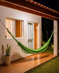 a hammock hanging from the side of a house at Chalé Romântico Privativo com Lareira e vista para Montanhas in Capela do Alto