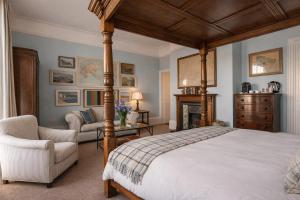 a bedroom with a canopy bed and a chair at The Royal Harbour Hotel in Ramsgate