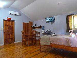 a bedroom with a bed and a tv on the wall at Cotton Tree Cabin at Freshwater Creek Cabanas in Hopkins
