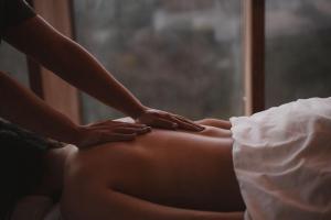a woman sitting on a bed getting a massage at Encuentro Guadalupe in Valle de Guadalupe +52 photos