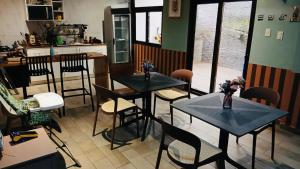 a restaurant with two tables and chairs and a kitchen at Hotel-cafetería TERRAVOLCAN in San Pedro Sacatepéquez