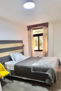 a bedroom with a large bed and a window at Hotel-cafetería TERRAVOLCAN in San Pedro Sacatepéquez