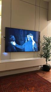 a large flat screen tv sitting on a wall at The Calm Suite in Al Khobar