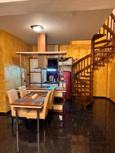 a kitchen and dining room with a table and a staircase at Central Point Apartment in Bar