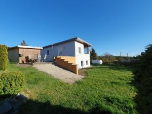 a small white house with a grass yard at Ferienhaus am Thüringer Meer in Bad Lobenstein