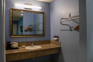 a bathroom with a sink and a mirror at Orange Tustin Inn in Orange in Orange +22 photos