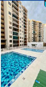 a swimming pool with tall buildings in the background at APARTAMENTO FAMIliar MELGAR v in Melgar