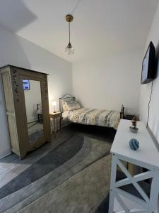 a small room with a bed and a mirror at Stylish Central Kettering Apartment by SJP in Kettering