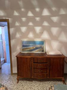 a wooden cabinet with a painting on the wall at Antique villa in Guardamar del Segura