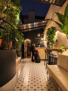 a woman standing at a bar in a restaurant at Ayni Living - Hostel in Lima