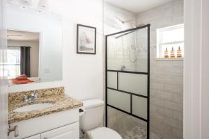 a bathroom with a shower and a toilet and a sink at Villa Summerfield Swim Spa in Summerfield +6 photos