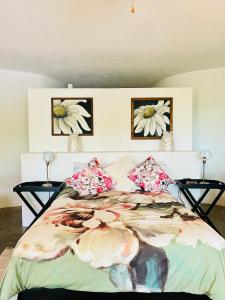 a bedroom with a bed with two pictures on the wall at Nandina Self Catering in Hazyview