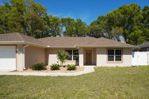 a house with a driveway and grass at Villa Summerfield Swim Spa in Summerfield