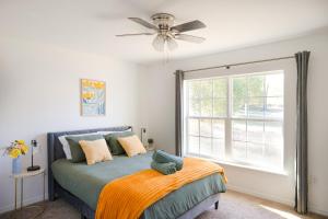 a bedroom with a bed with a ceiling fan and a window at Villa Summerfield Swim Spa in Summerfield