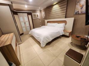 a bedroom with a large white bed and a table at دار ناصر in Riyadh