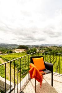 a black chair with an orange pillow on a balcony at Outeyro Retreat Country House in Marco de Canaveses +93 photos