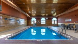 a swimming pool with blue water in a building at Miles City Hotel & Suites in Miles City