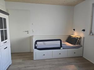 a small white bedroom with a bed in it at Bodensee Living Ferienwohnung Wald in Wald +2 photos