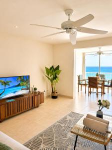 a living room with a flat screen tv and a ceiling fan at Grand Case Beachfront Apartment, Perfect for a couple looking a romantic Gateway in Grand Case