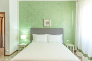 a bed in a room with a green wall at Residenza Subasio Assisi in Rivotorto