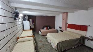 a room with two beds and a refrigerator at BelDaMar in Capilla del Monte