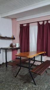 a wooden table in a room with red curtains at BelDaMar in Capilla del Monte +12 photos