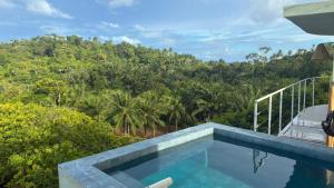 a swimming pool with a view of a forest at Casa Luar da Sereia - Itacaré in Itacaré