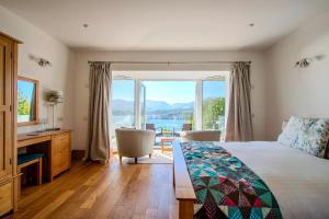 a bedroom with a bed and a view of the water at Seascape at coed y berclas, luxury accommodation with stunning sea view in Llandegfan