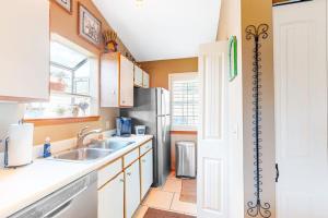 a kitchen with a sink and a refrigerator at Woodpecker's Tree in Branson +28 photos