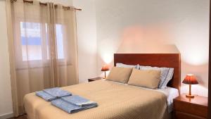 a bedroom with a bed with two towels on it at Apartamento Sto Estevão in Zambujeira do Mar