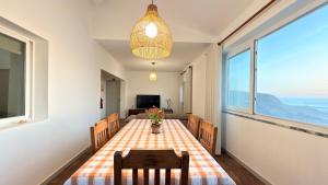 a dining room with a table and chairs and a window at Apartamento Sto Estevão in Zambujeira do Mar