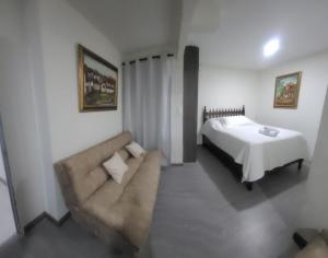 a living room with a bed and a couch at BED & Breakfast in Bogotá